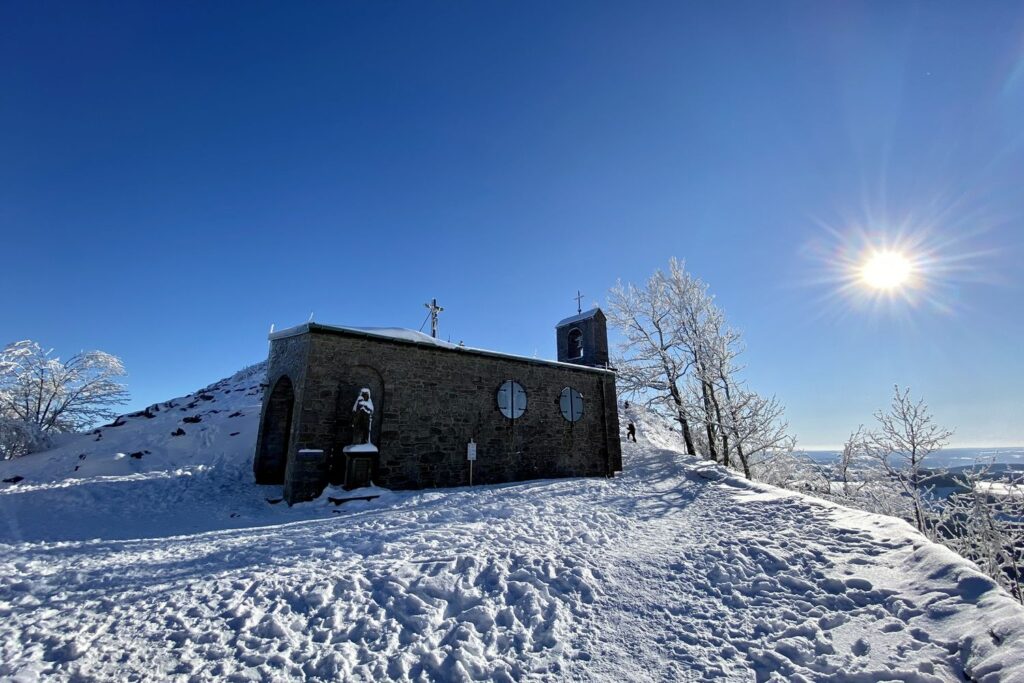 Die verschneite Gangolfskapelle auf dem Gipfel der Milseburg bei Sonnenschein