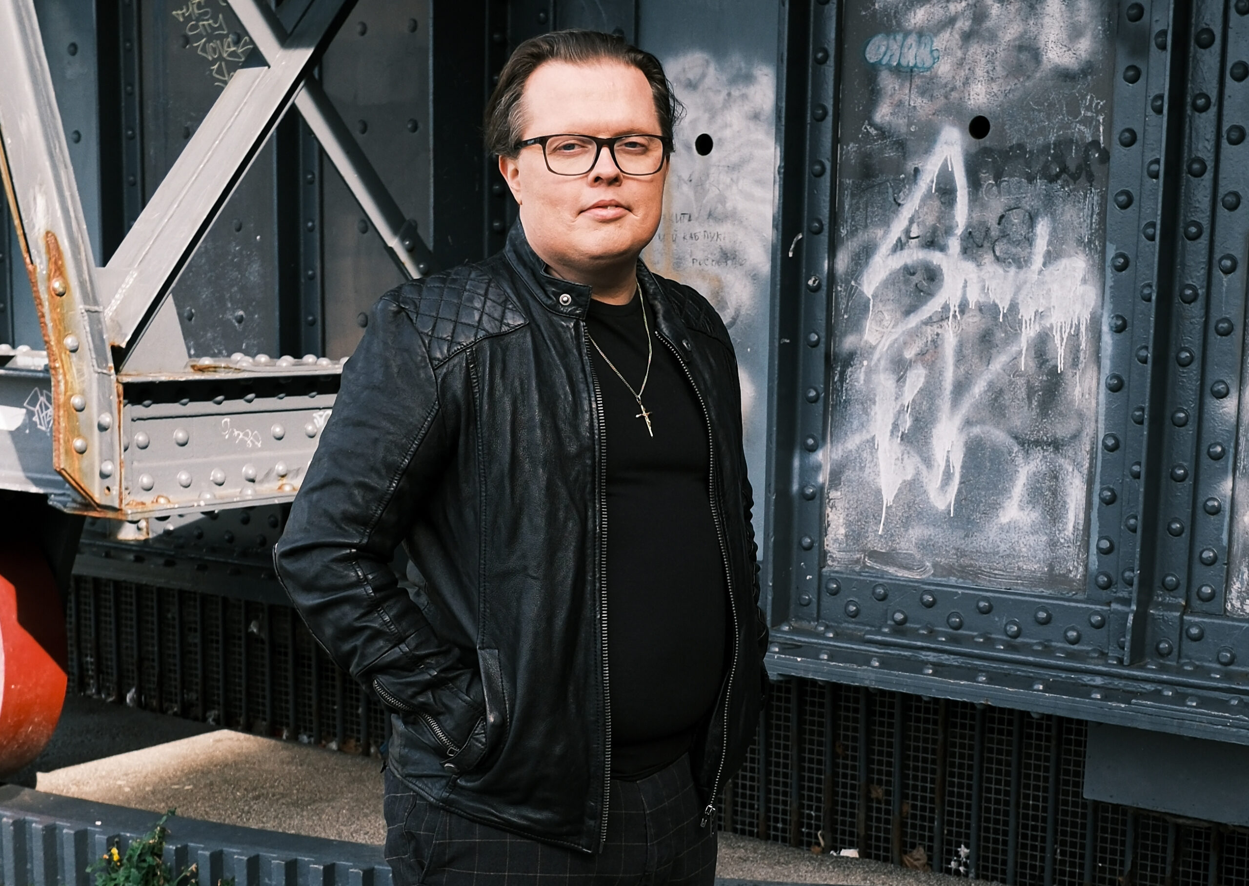 Angelo Kelly in Lederjacke vor einer Stahlbrücke