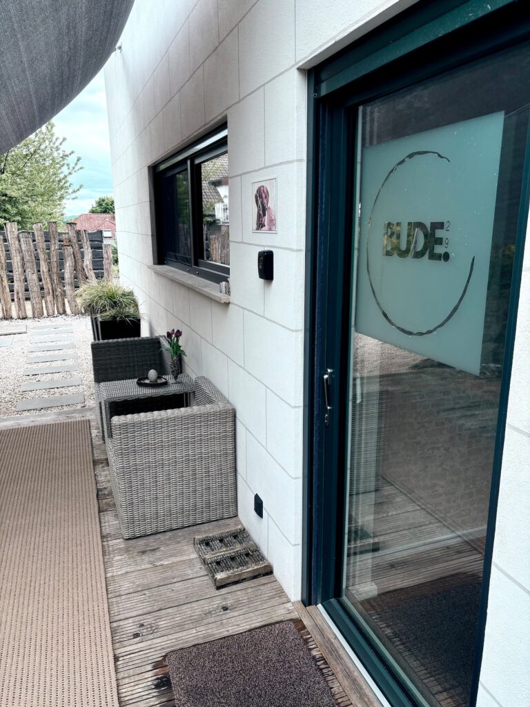 Glastür mit BUDE-Schriftzug am Eingang der Ferienwohnung