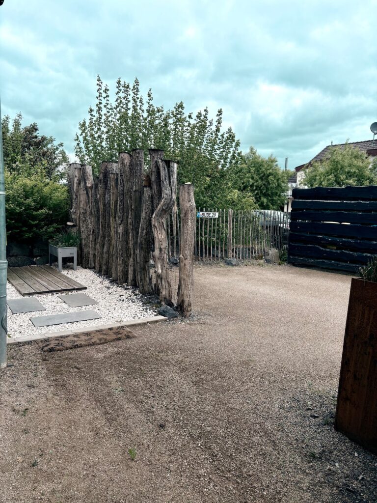 Gekiester Innenhof der BUDE.29 mit Holzstelen und Trittplatten