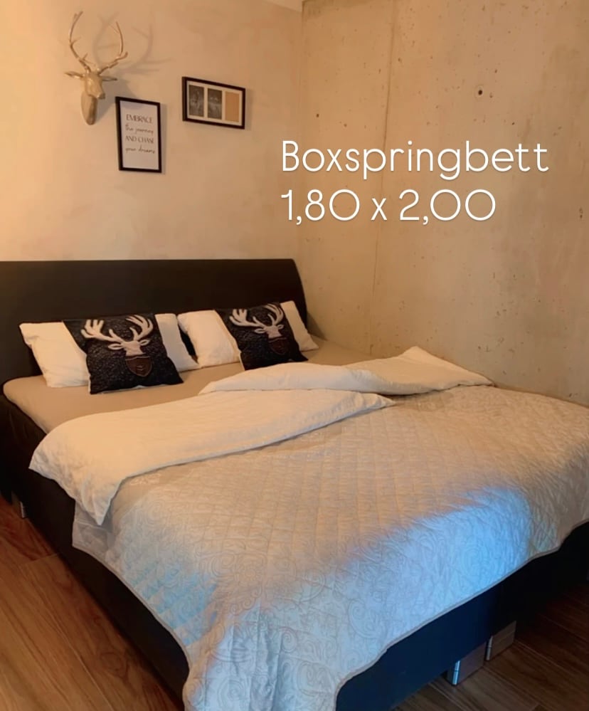 Schlafzimmer der BUDE.29 mit Boxspringbett, 1,80 × 2,00 Meter