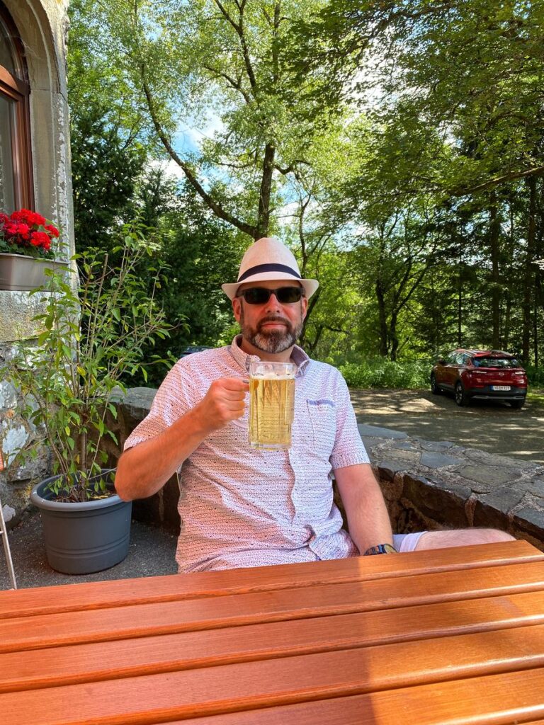 Steffen von FuldaRhön mit einem Bier auf der Terrasse am Jagdschloss Holzberghof