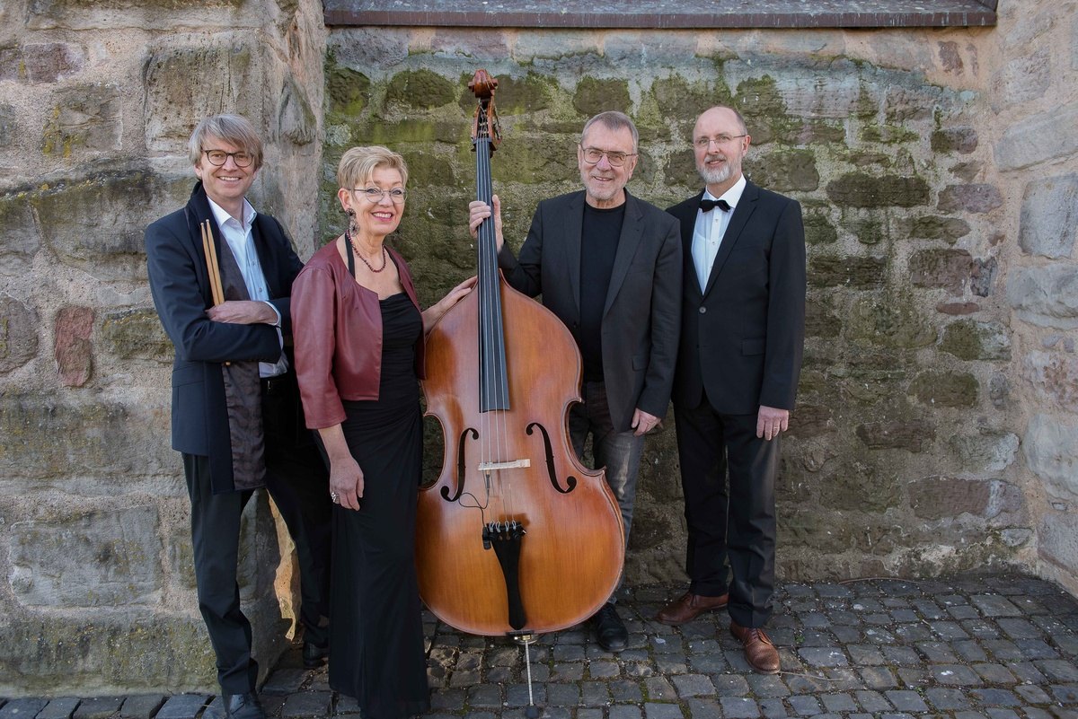 Die LöBand mit Kontrabass vor einer Sandsteinmauer
