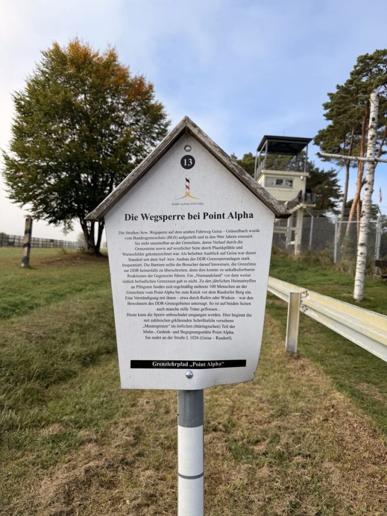 Tafel 13 des Grenzlehrpfads Point Alpha zur Wegsperre, dahinter der US-Beobachtungsturm