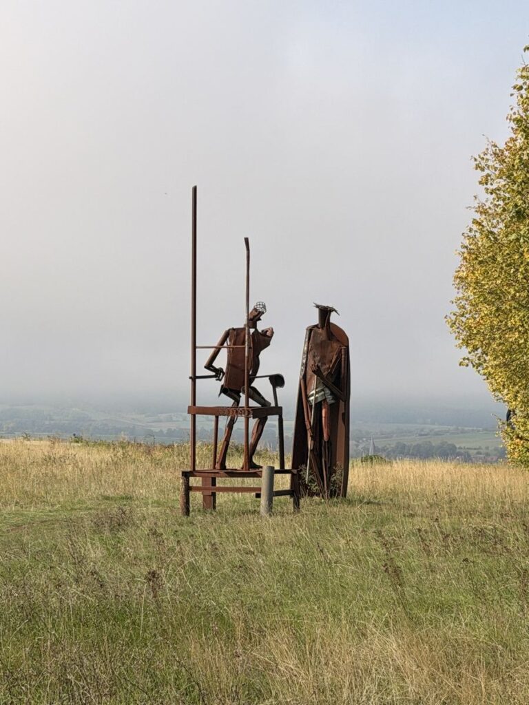 Eisenskulptur am Weg der Hoffnung vor dem nebligen Ulstertal