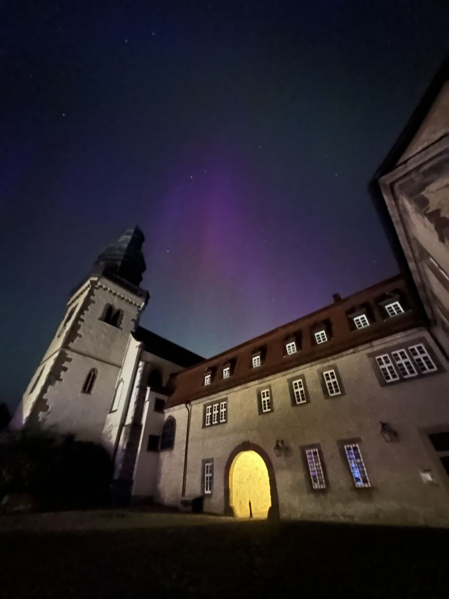 Rot-violettes Polarlicht über der Propstei Johannesberg in Fulda in der Nacht zum 11. Mai 2024.