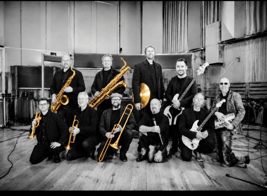 Das United Brass & Rock Ensemble mit Bläsern und Gitarren in einem Aufnahmestudio
